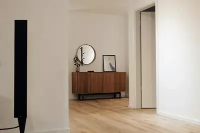 Ljus hall med vita väggar och trägolv