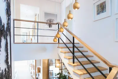 Ljust trapphus med trätrappa och räcke